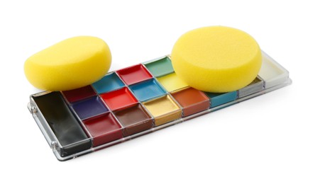 Photo of Bright face paint palette and sponges isolated on white