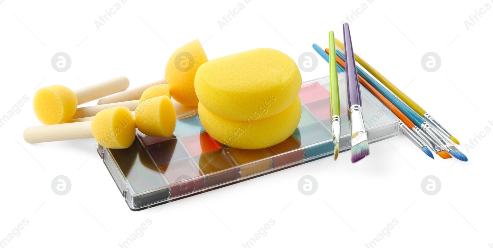 Photo of Bright face paint palette, brushes and sponges isolated on white