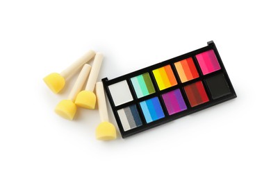 Photo of Bright face paint palette and sponges isolated on white, top view