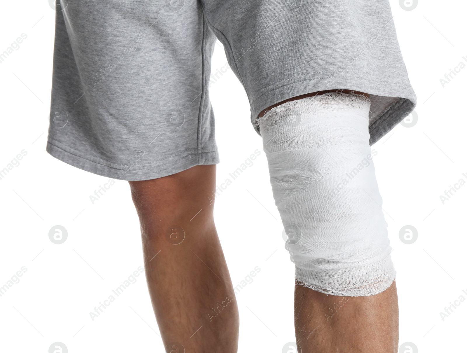 Photo of Man with medical bandage on his knee against white background, closeup