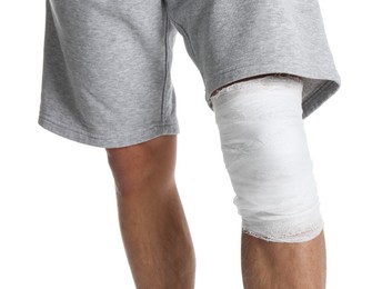 Photo of Man with medical bandage on his knee against white background, closeup