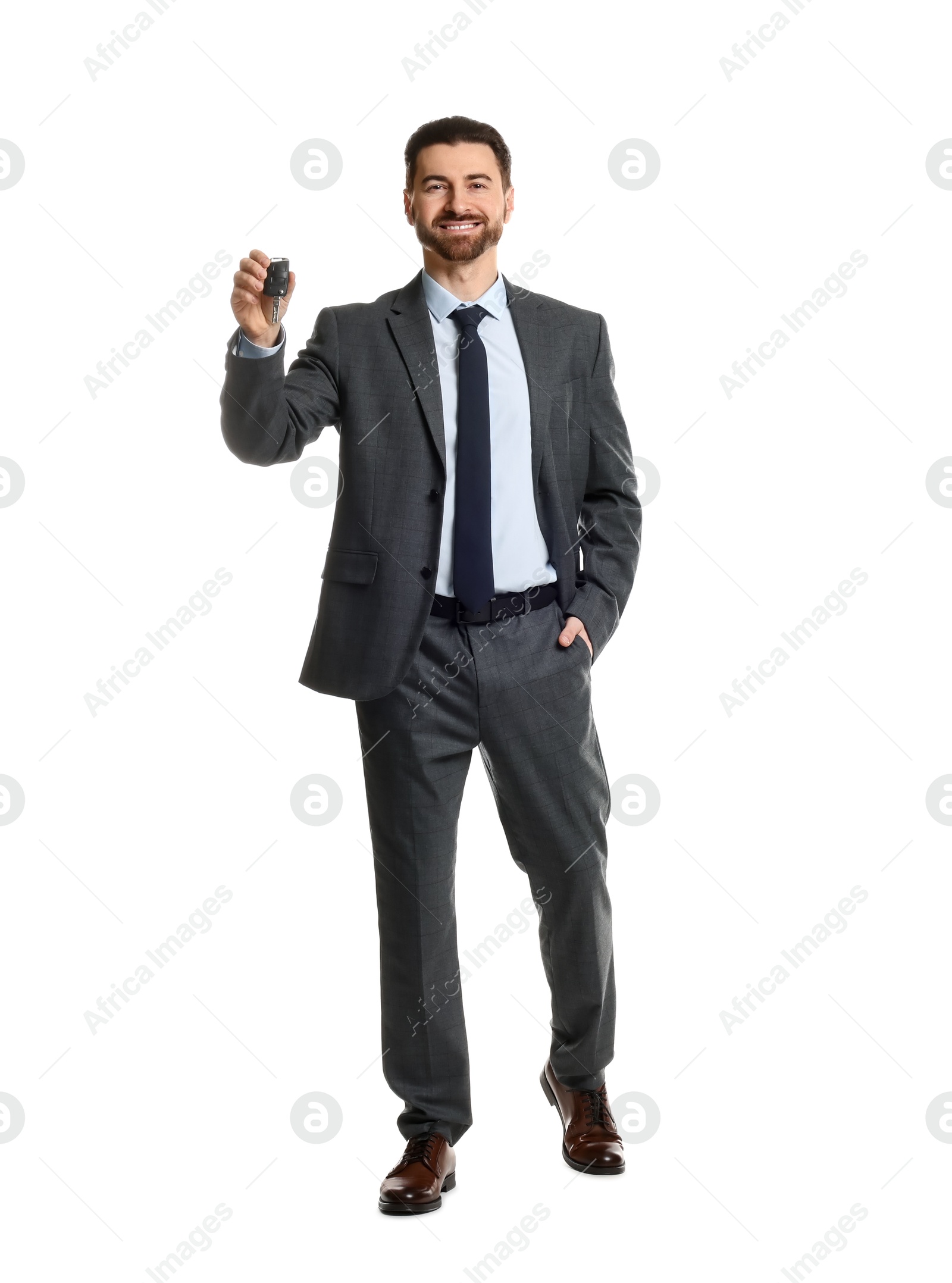 Photo of Cheerful salesman with car key on white background