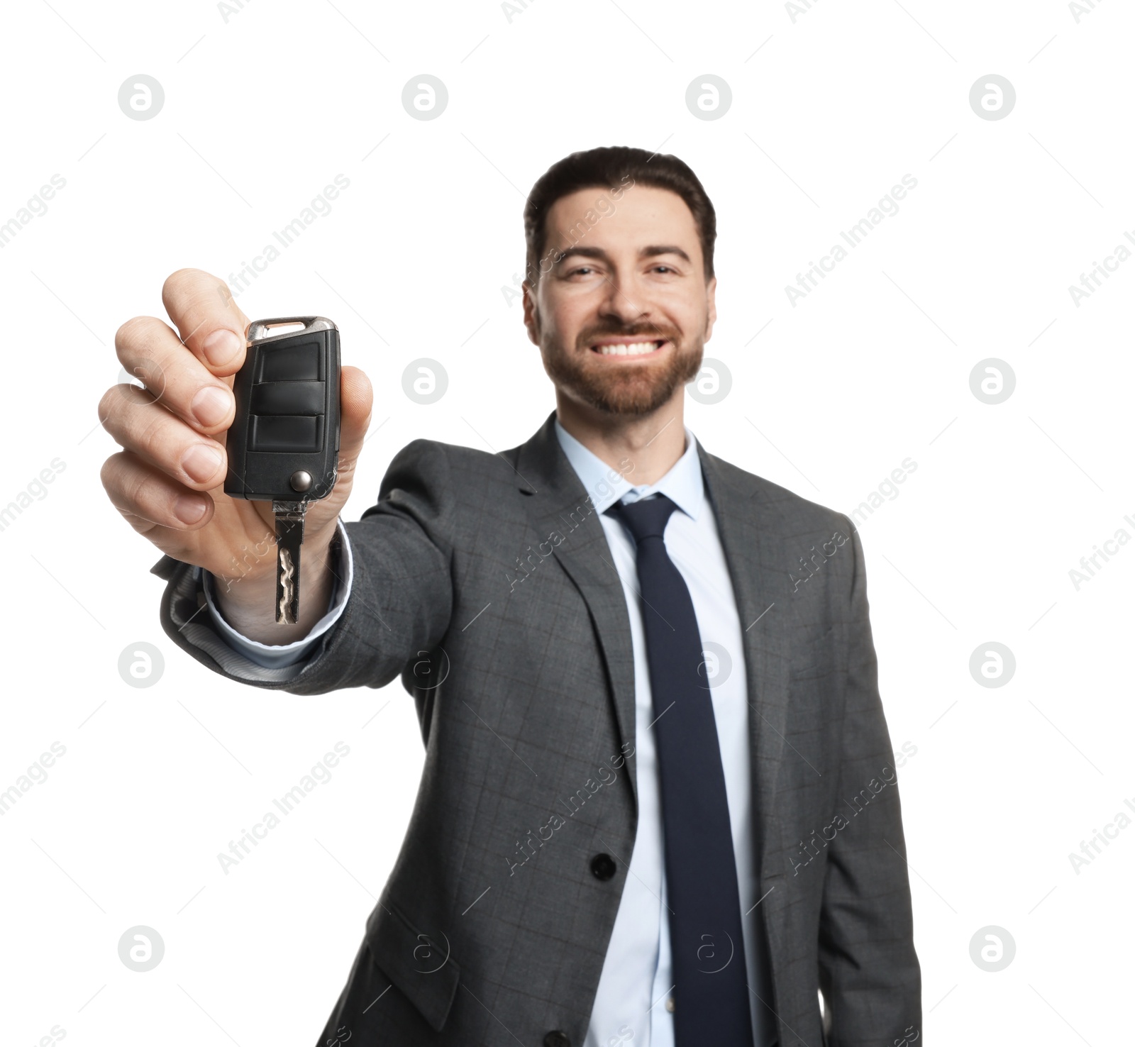 Photo of Cheerful salesman with car key on white background