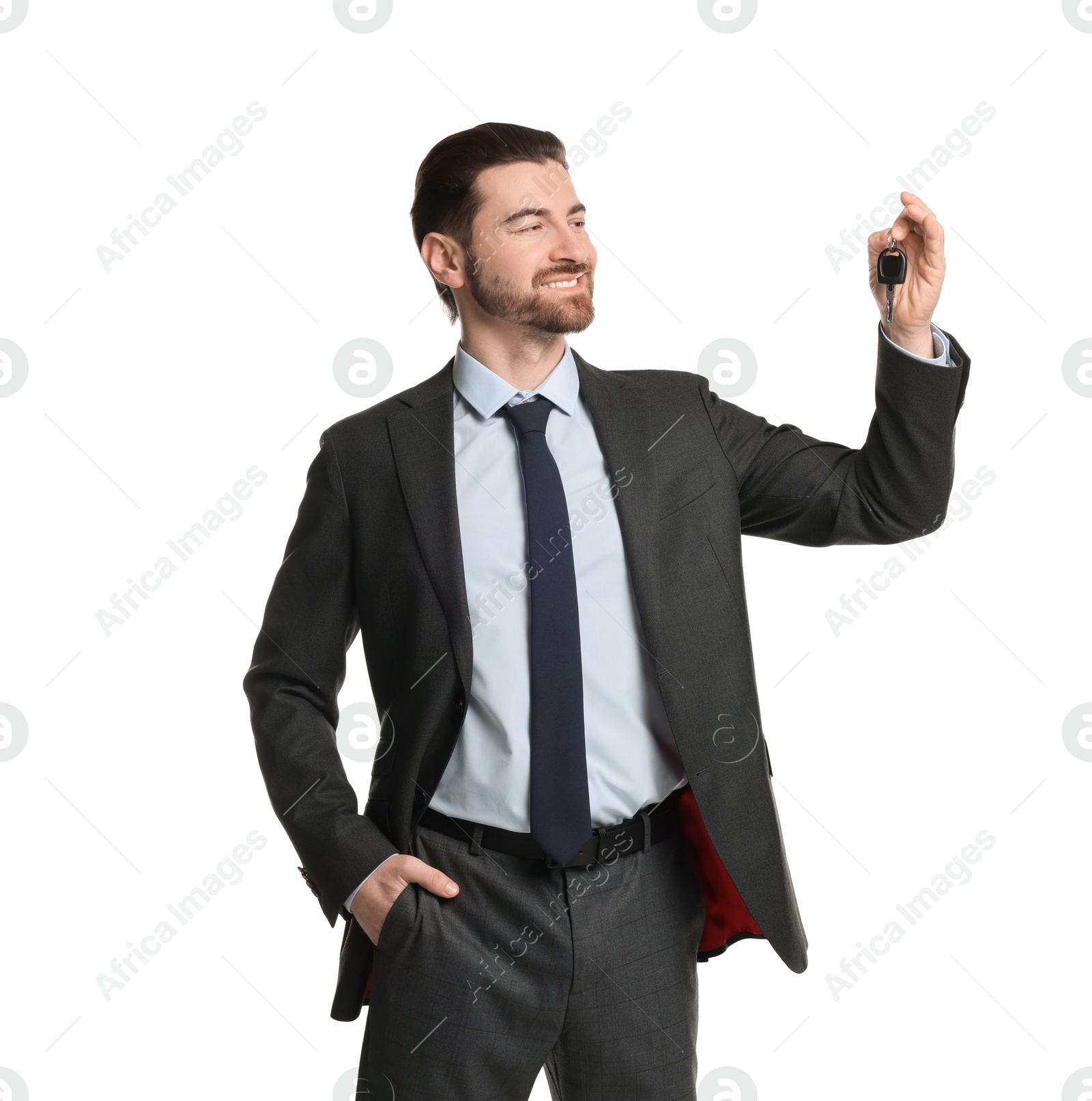 Photo of Cheerful salesman with car key on white background