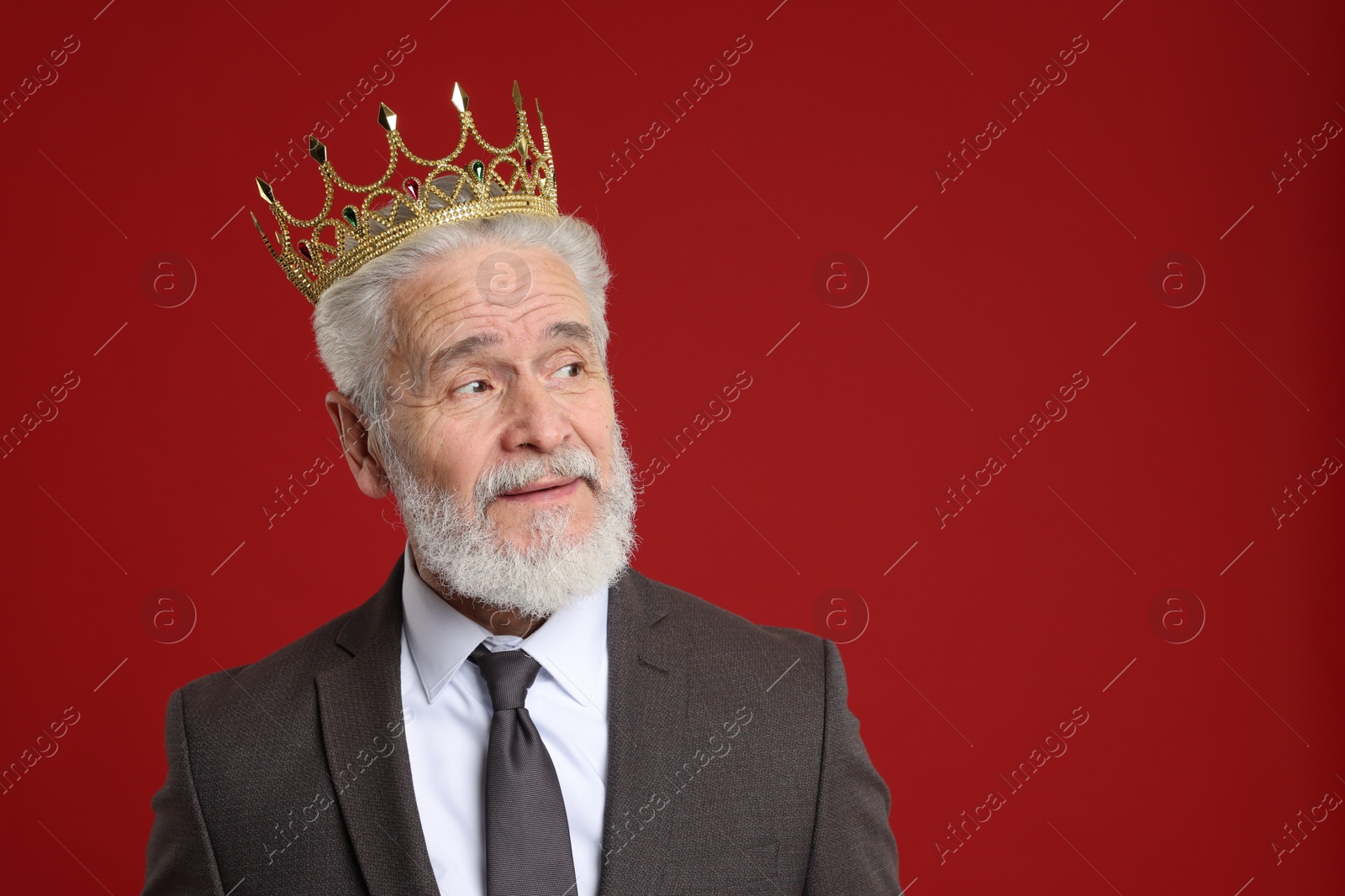 Photo of Senior man wearing luxury crown on red background, space for text