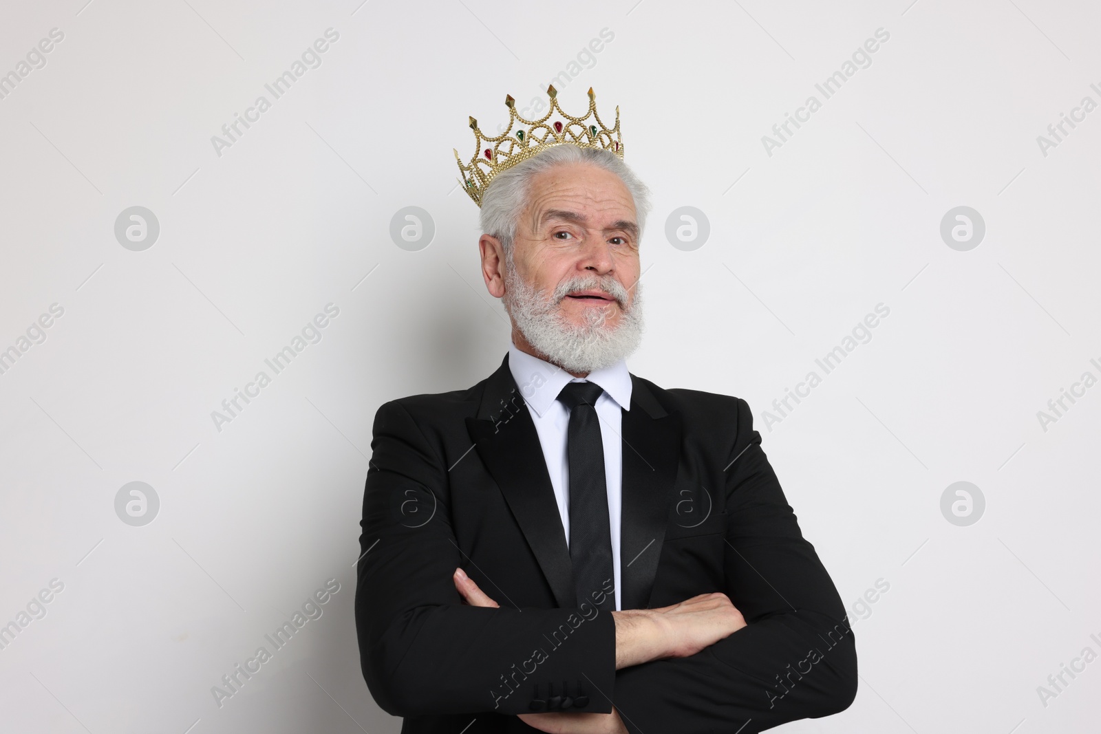 Photo of Senior man wearing luxury crown on white background