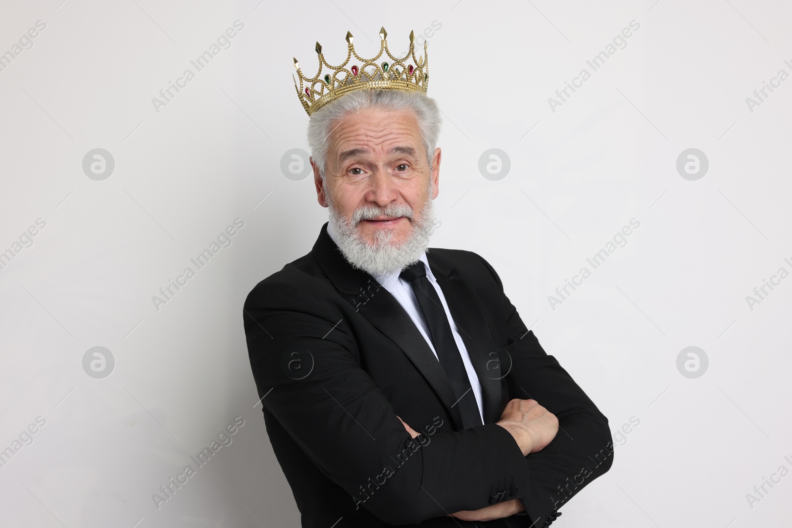 Photo of Senior man wearing luxury crown on white background