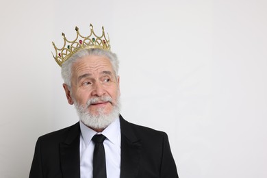 Photo of Senior man wearing luxury crown on white background, space for text