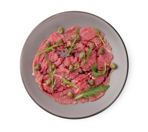 Fresh beef carpaccio with arugula, capers and sauce isolated on white, top view