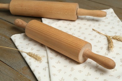 Photo of Rolling pins, spikes and napkin on wooden table, closeup