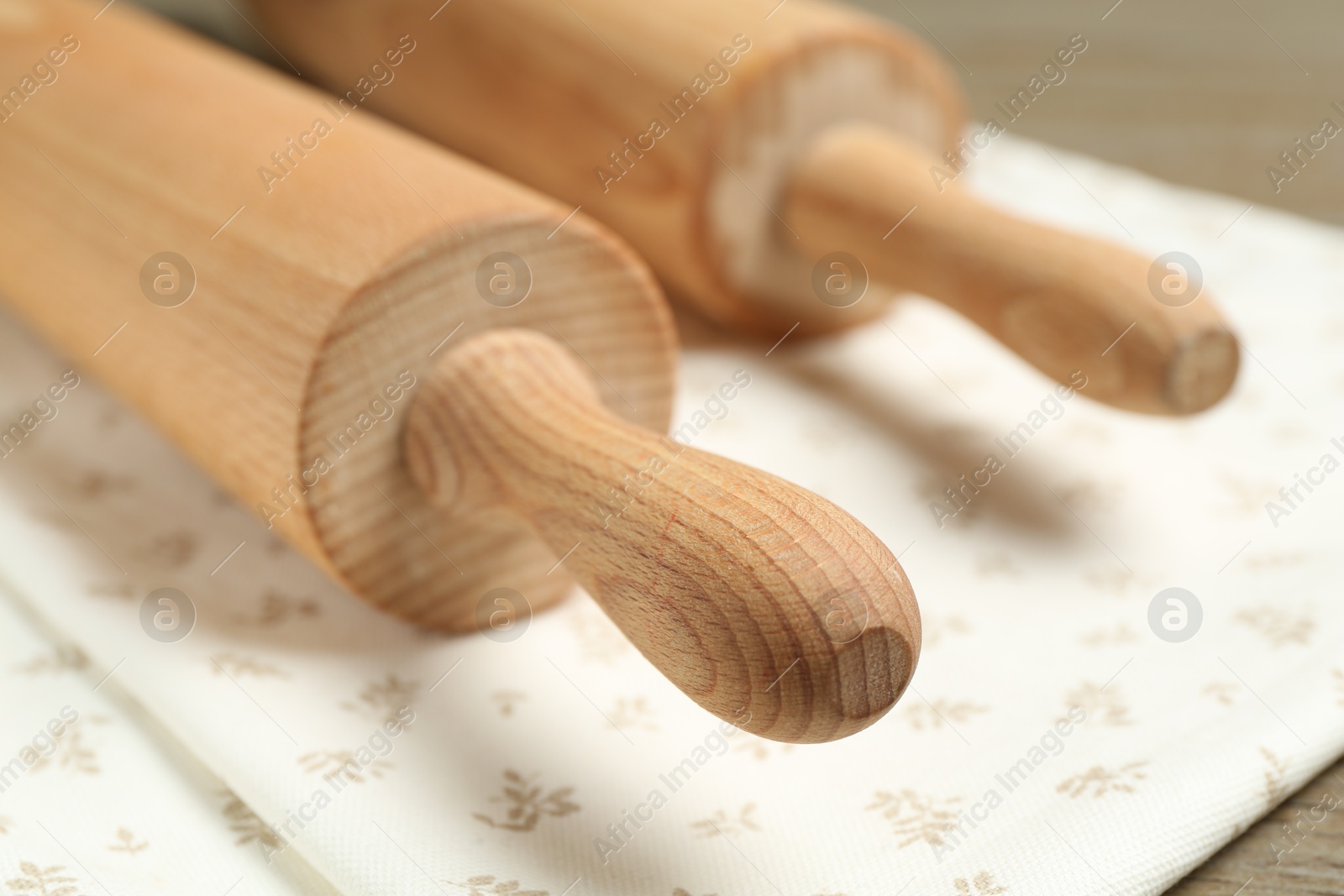 Photo of Rolling pins and napkin on table, closeup