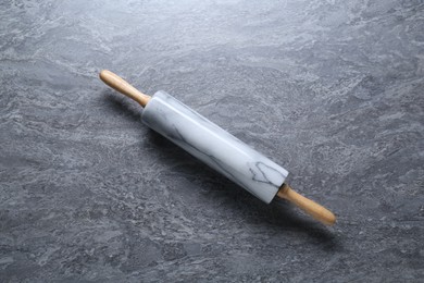 Photo of One rolling pin on grey textured table, top view