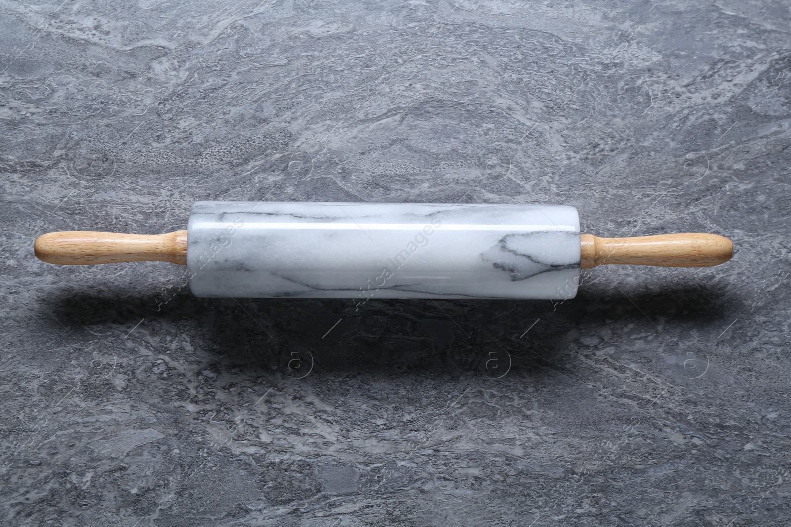 Photo of One rolling pin on grey textured table, top view