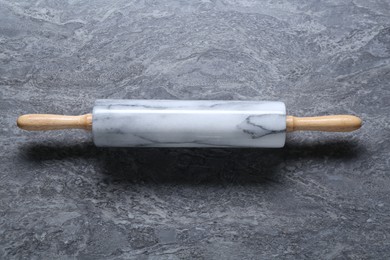 Photo of One rolling pin on grey textured table, top view