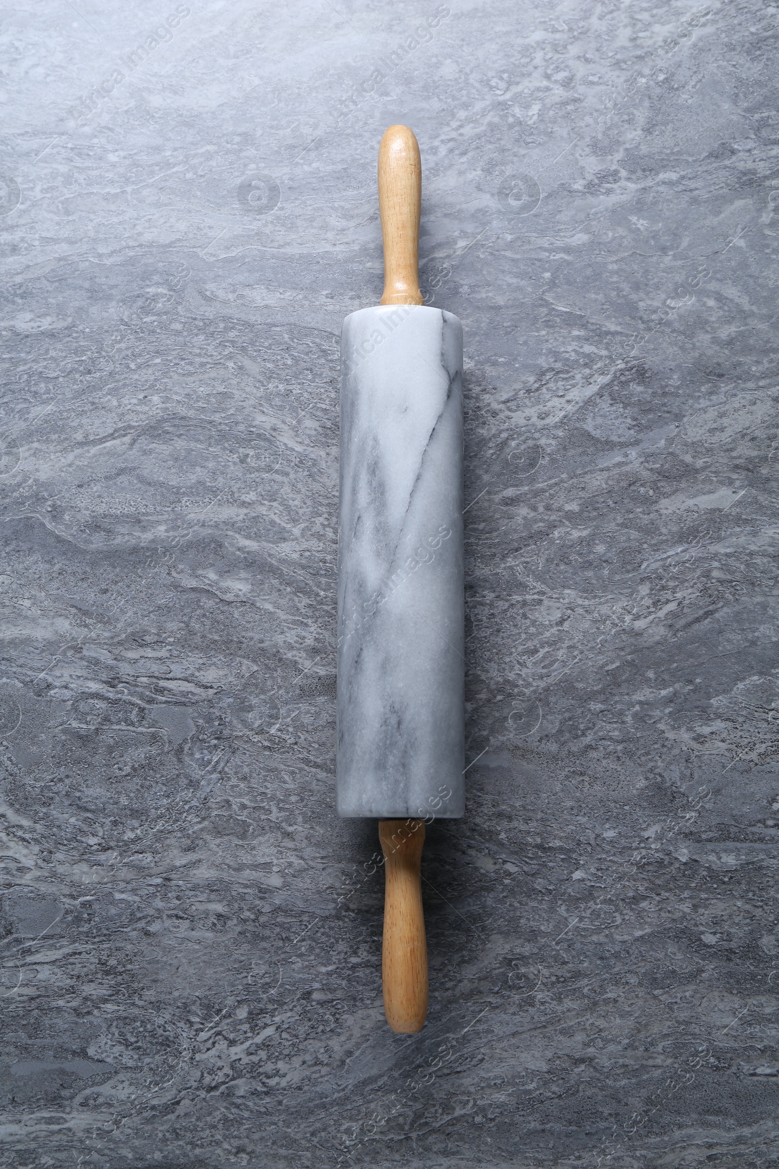 Photo of One rolling pin on grey textured table, top view