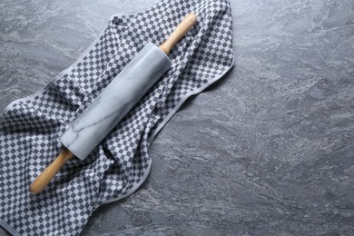 Photo of One rolling pin on grey textured table, top view. Space for text