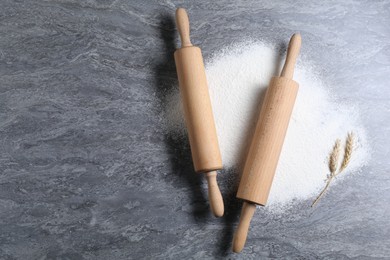 Photo of Rolling pins, flour and spikes on grey textured table, flat lay. Space for text