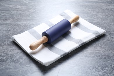 Photo of Rolling pin on grey textured table, closeup