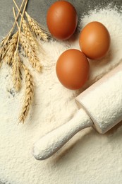 Photo of Wooden rolling pin, eggs, flour and spikes on table, flat lay