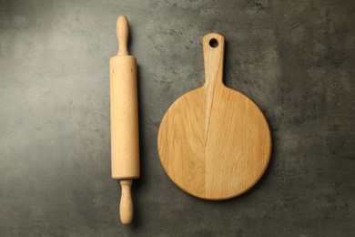 Photo of Wooden rolling pin and board on grey table, flat lay