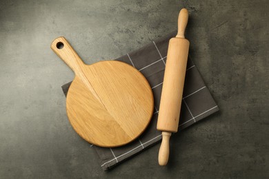 Photo of Wooden rolling pin and board on grey table, flat lay