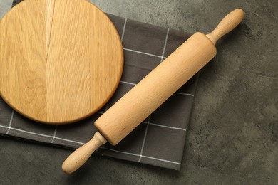 Photo of Wooden rolling pin and board on grey table, flat lay