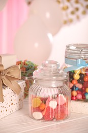 Photo of Candy bar. Many different sweets and gift boxes on white wooden table indoors