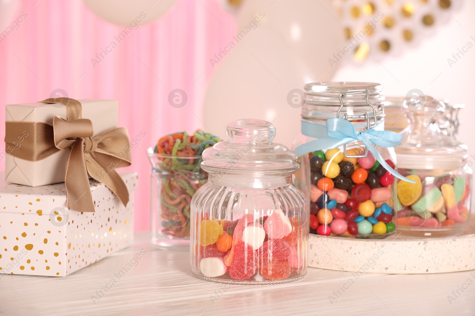 Photo of Candy bar. Many different sweets and gift boxes on white wooden table indoors