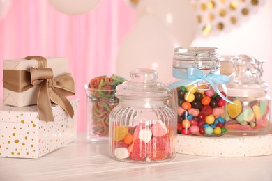 Photo of Candy bar. Many different sweets and gift boxes on white wooden table indoors