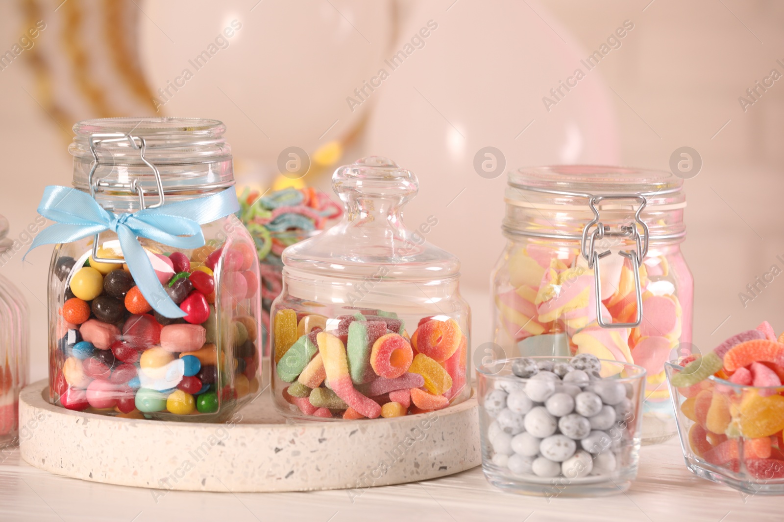 Photo of Candy bar. Many different sweets on white wooden table in festive decorated room