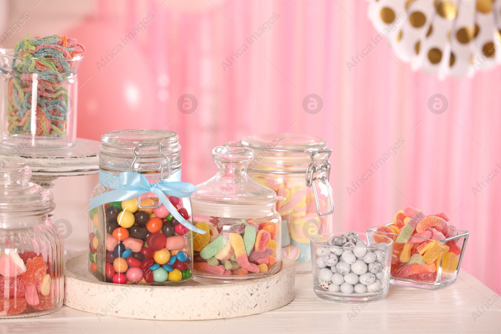 Photo of Candy bar. Many different sweets on white wooden table in festive decorated room