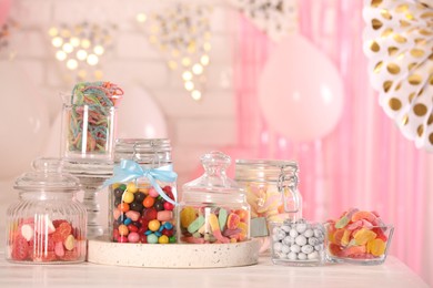 Photo of Candy bar. Many different sweets on white wooden table in festive decorated room