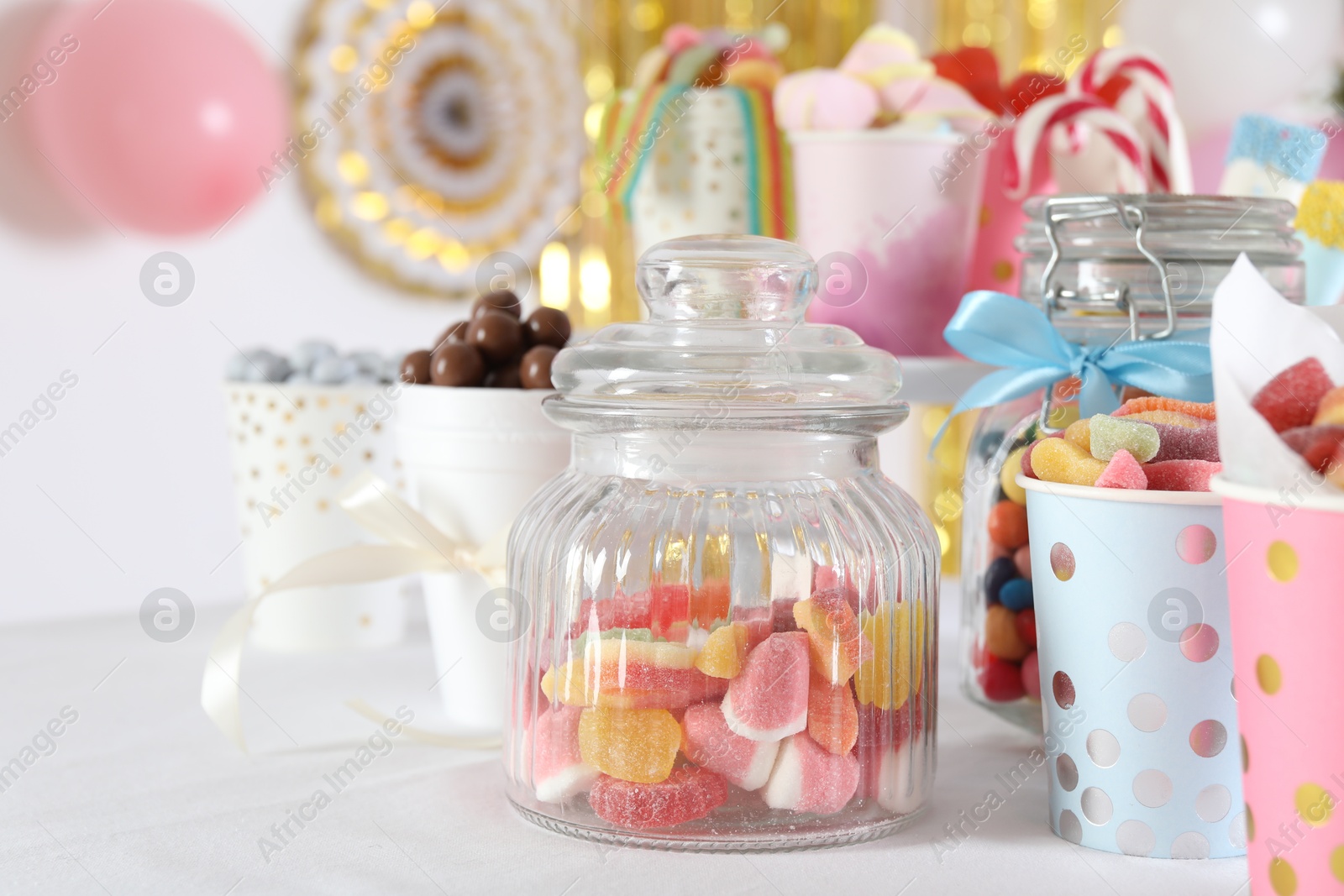 Photo of Candy bar. Many different sweets on table in festive decorated room