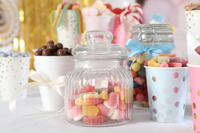 Photo of Candy bar. Many different sweets on table in festive decorated room