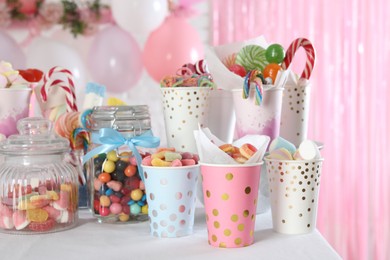 Photo of Candy bar. Many different sweets on table in festive decorated room