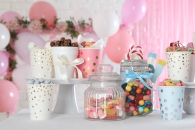 Photo of Candy bar. Many different sweets on table in festive decorated room