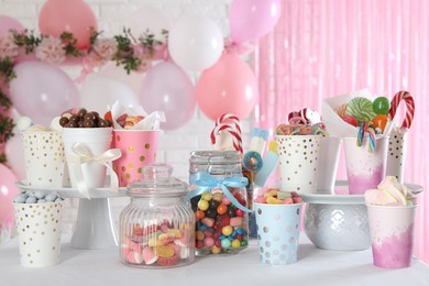 Photo of Candy bar. Many different sweets on table in festive decorated room