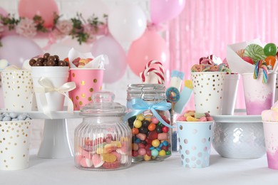 Photo of Candy bar. Many different sweets on table in festive decorated room