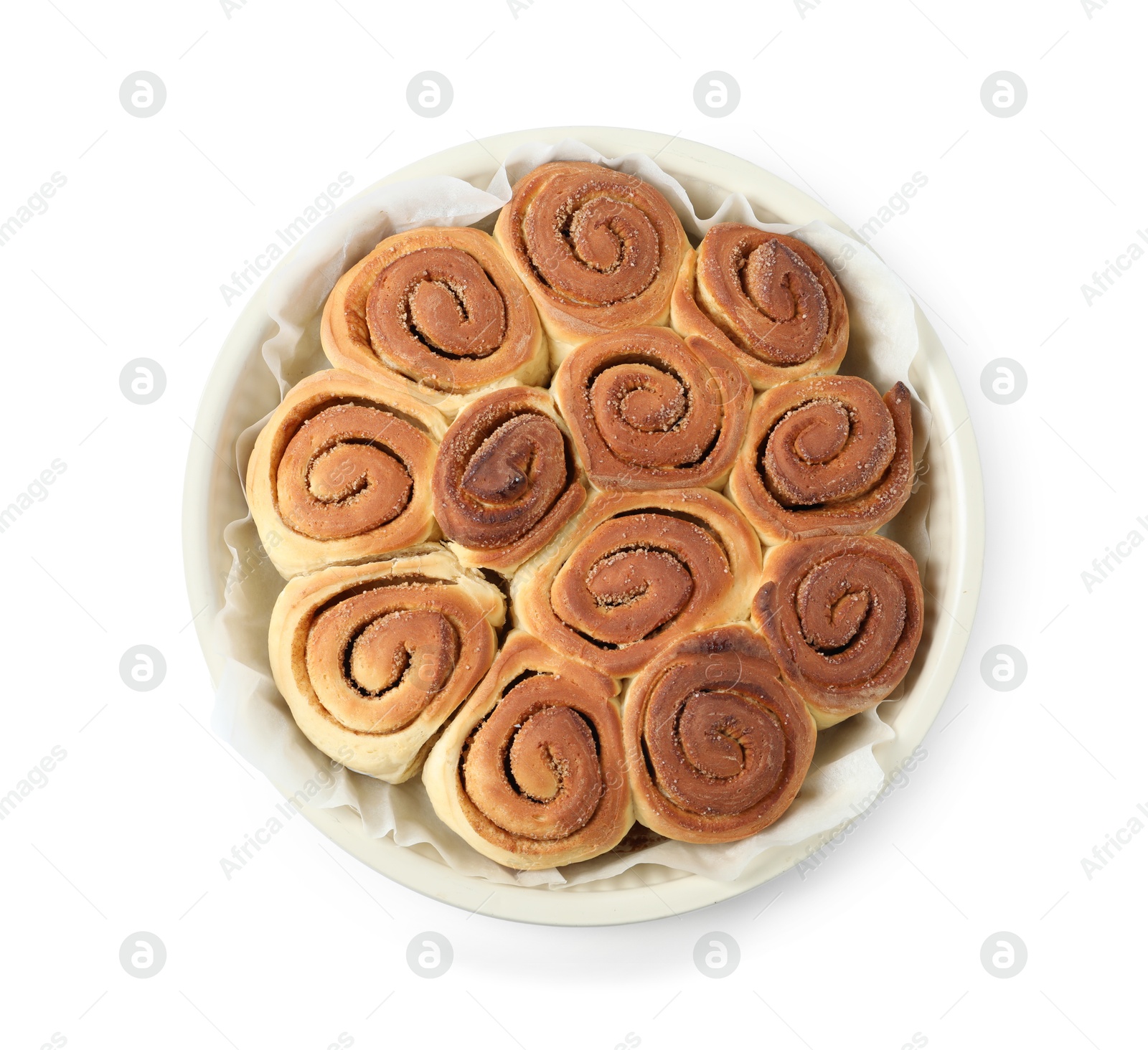 Photo of Freshly baked cinnamon rolls in baking dish isolated on white, top view