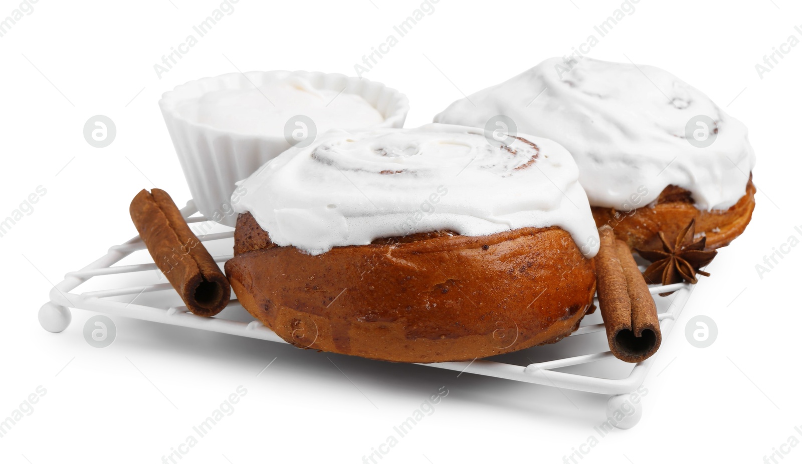 Photo of Tasty cinnamon rolls with cream and spices isolated on white