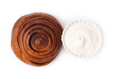 Photo of Tasty cinnamon roll with cream isolated on white, top view