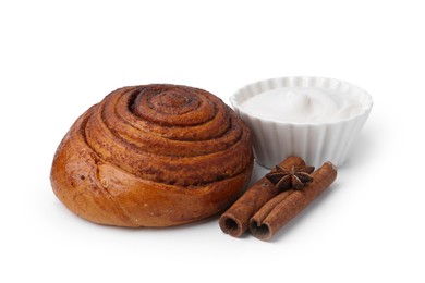 Photo of Tasty cinnamon roll with cream and sticks isolated on white