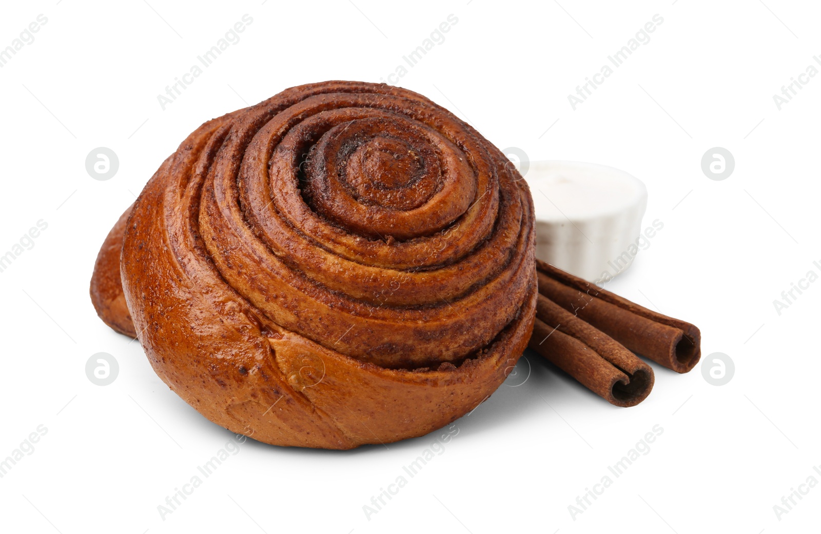 Photo of Tasty cinnamon roll with cream and sticks isolated on white