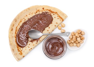 Photo of Tasty crepe with chocolate butter and hazelnuts isolated on white, top view