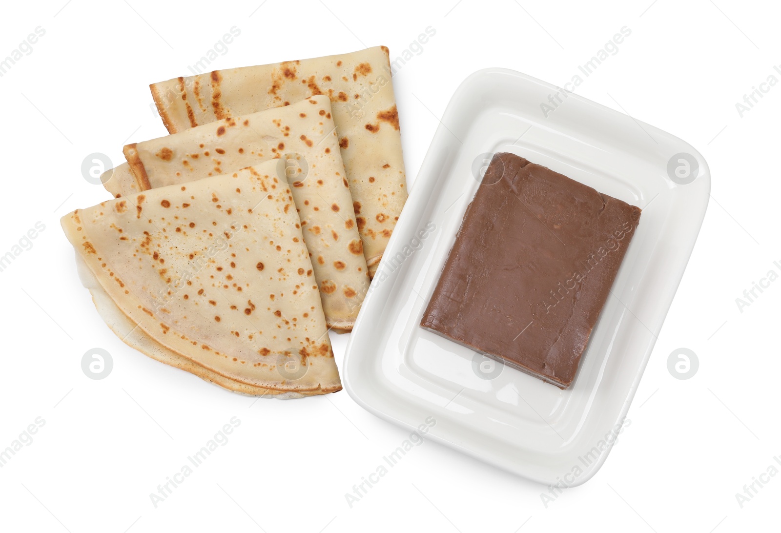 Photo of Tasty crepes with chocolate butter isolated on white, top view