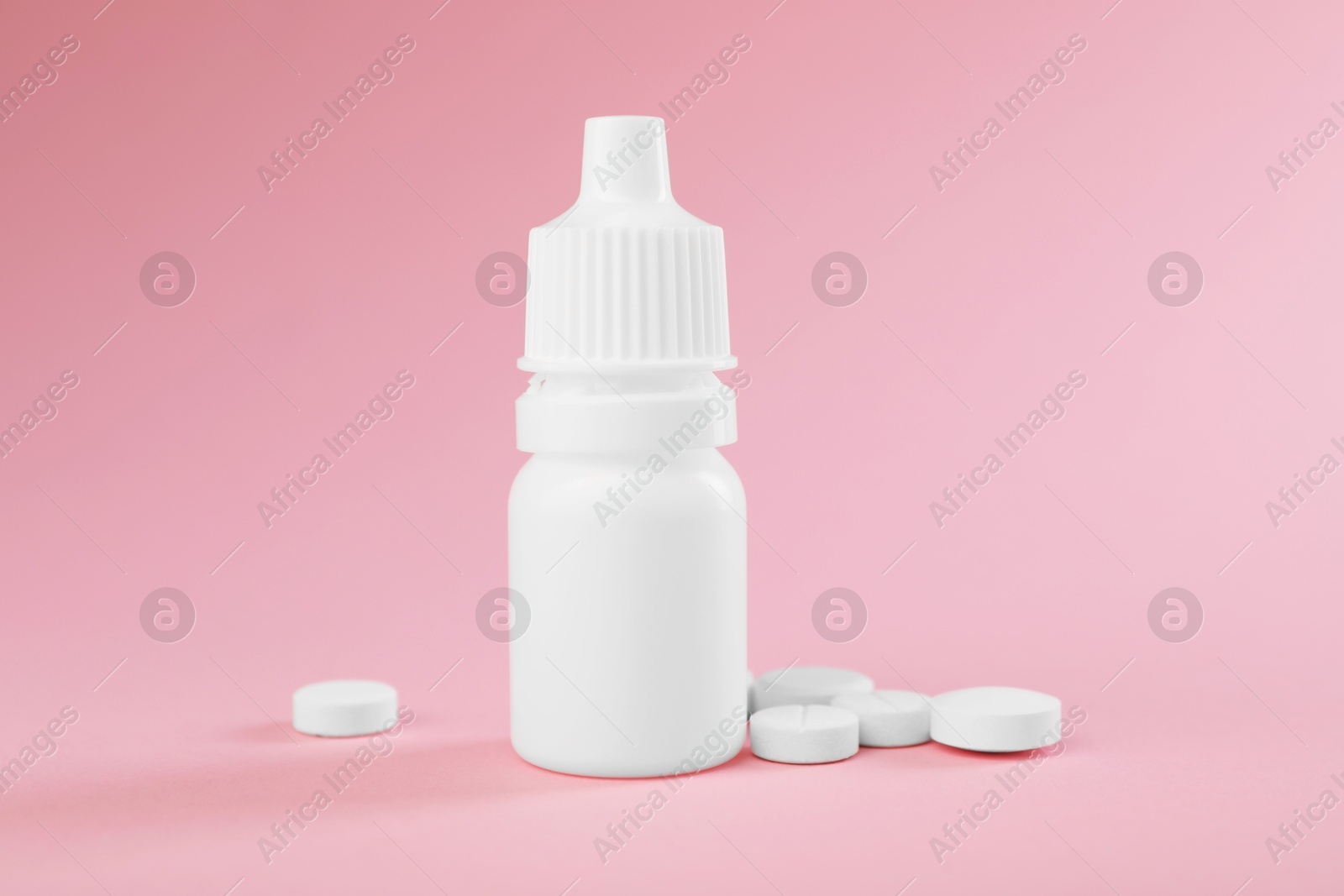 Photo of Allergy treatment. Nasal drops and pills on pink background, closeup