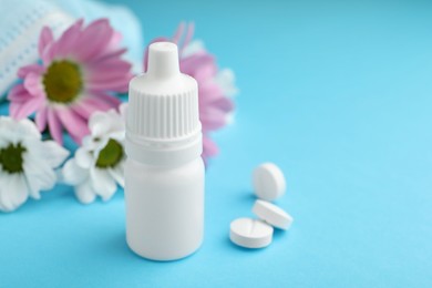 Photo of Allergy treatment. Nasal drops, pills and flowers on light blue background, closeup. Space for text