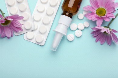 Photo of Allergy treatment. Nasal spray, pills and flowers on light blue background, flat lay. Space for text