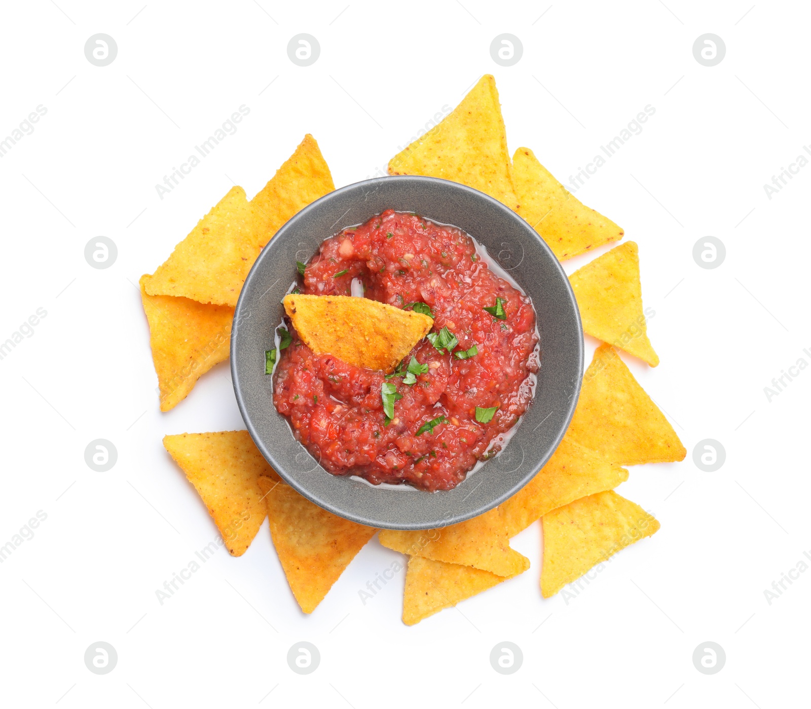 Photo of Delicious spicy salsa sauce in bowl and nacho chips isolated on white, top view