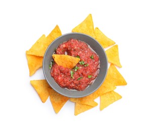 Delicious spicy salsa sauce in bowl and nacho chips isolated on white, top view